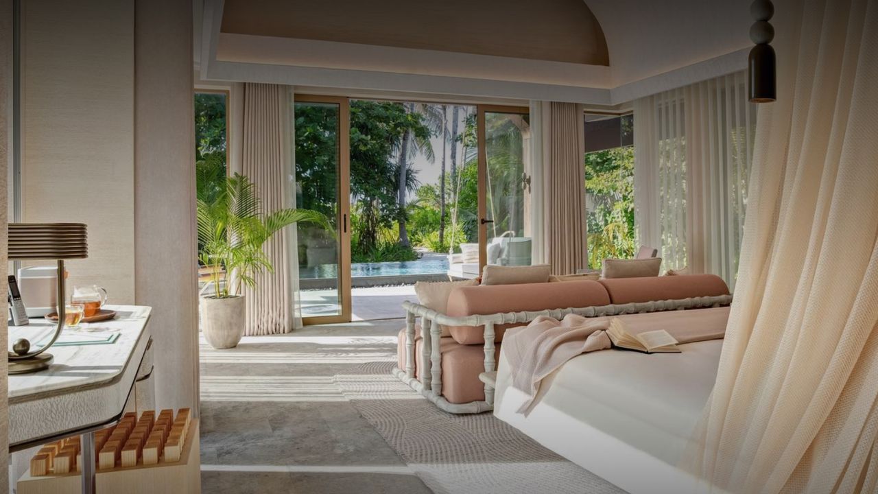 Beach villa at JOALI Maldives shaded by palm trees