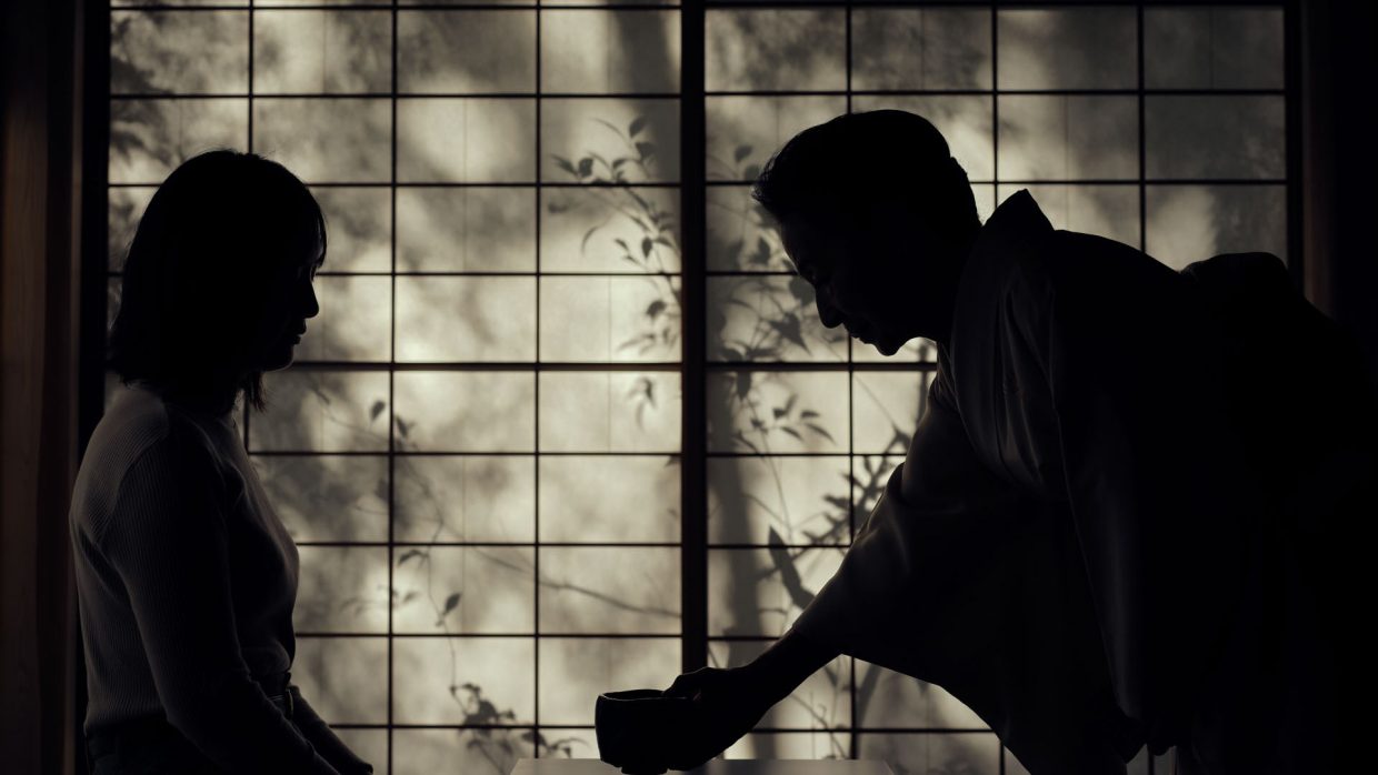 black and white photo of a Japanese man performing a tea ceremony