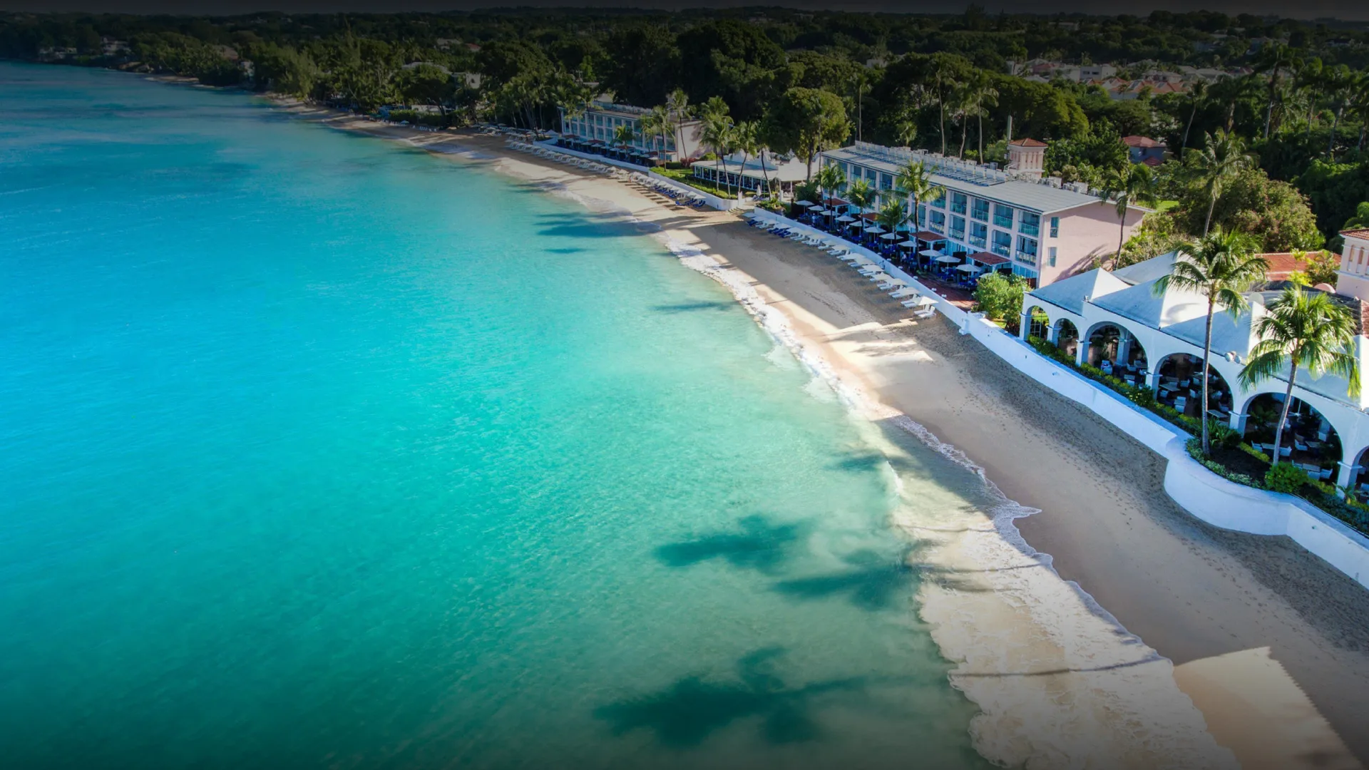 Aerial view of Fairmont Royal Pavilion in Barbados along a white-sand beach and turquoise Caribbean water.