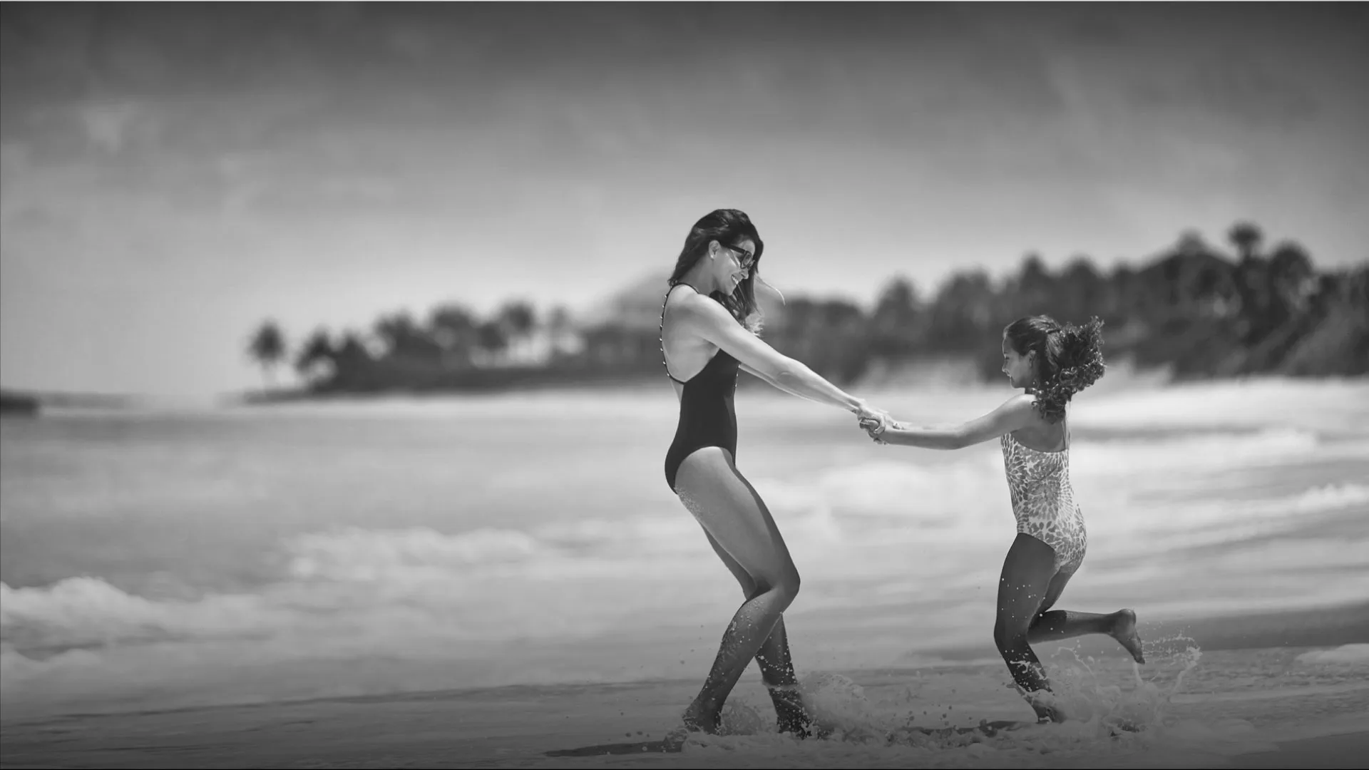 Woman and child playing on the beach at Four Seasons Ocean Club, Bahamas