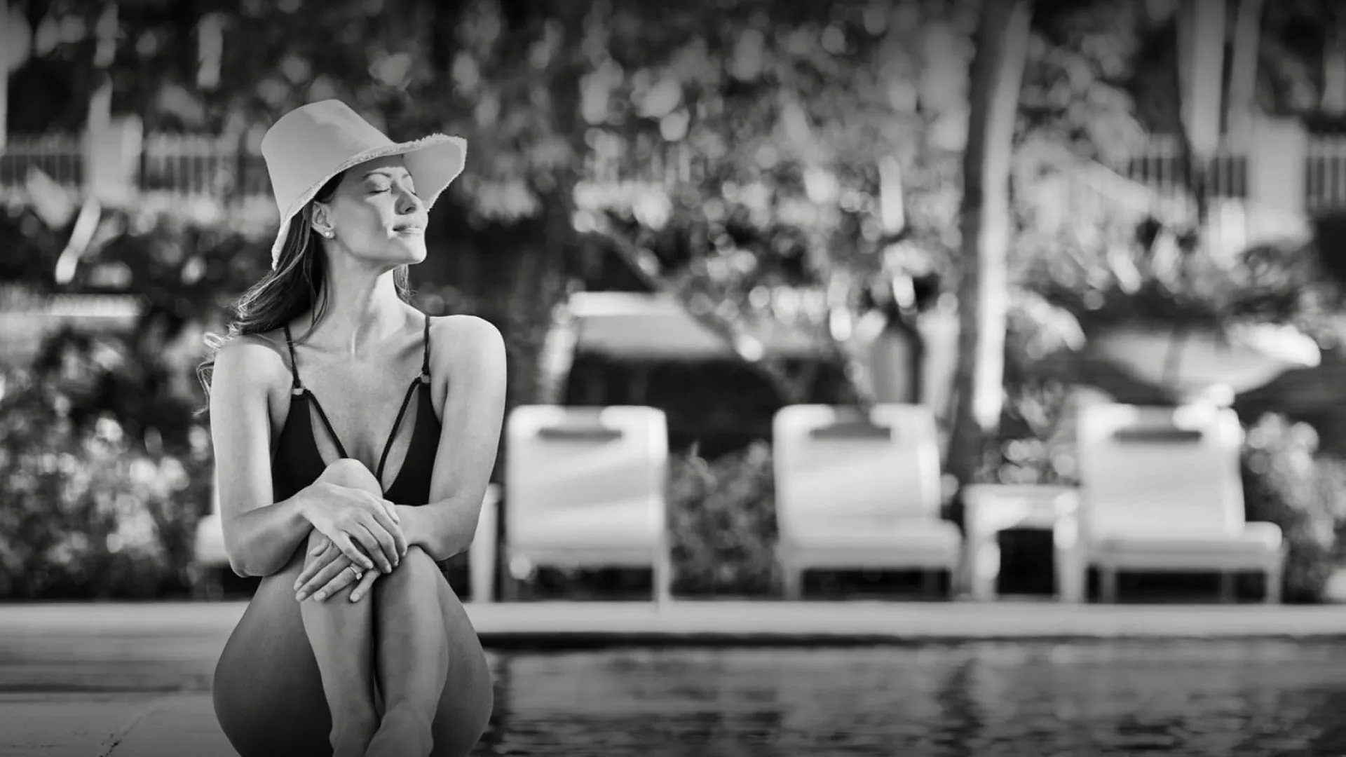 Woman relaxing by the pool at Four Seasons Ocean Club, Bahamas