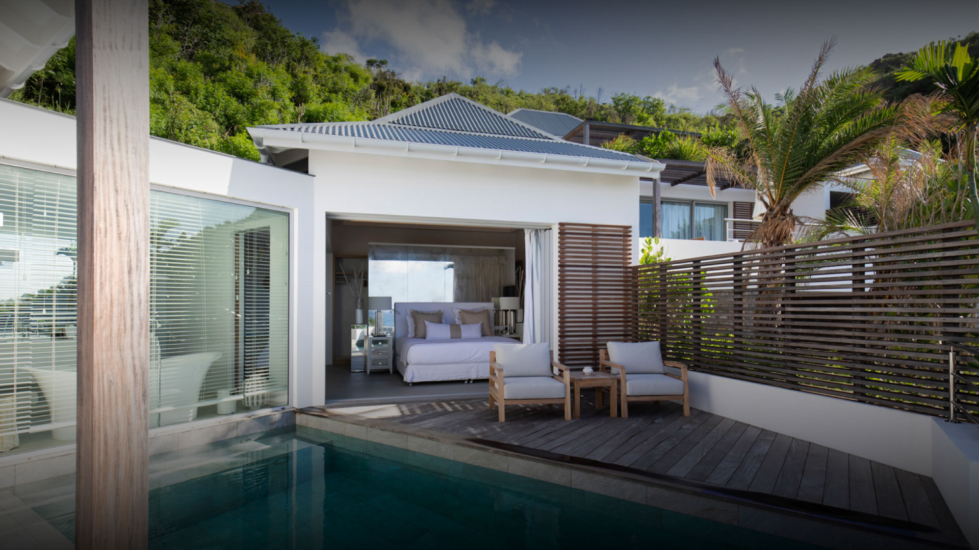 Private villa plunge pool and open bedroom terrace surrounded by tropical greenery at Hotel Le Toiny