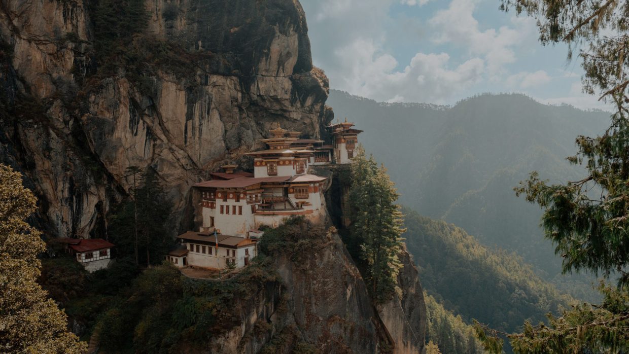 Tiger's Nest monastery (Paro Taktsang) clinging to a cliffside above the forested Paro Valley, Bhutan