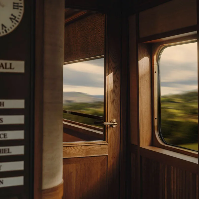Countryside rushing past the observation car windows aboard the Britannic Explorer, A Belmond Train