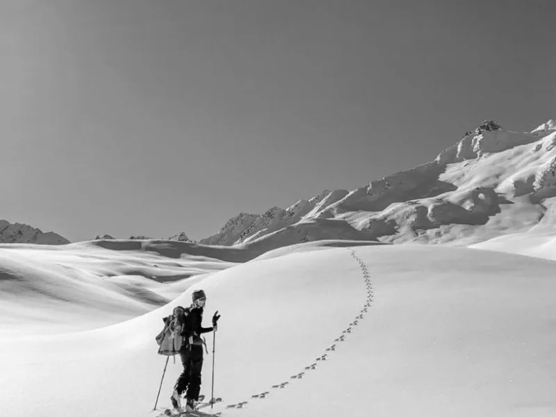 Ski tourer climbing through fresh powder in the mountains above Val d'Isere