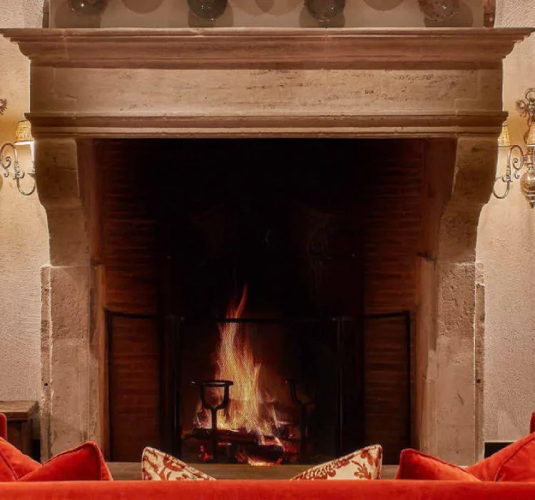 Open fire in the grand stone fireplace at Airelles Val d'Isere
