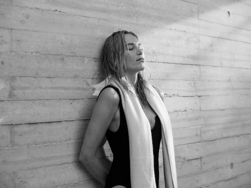 Guest resting against a wall with a towel after a swim at Lanserhof Sylt