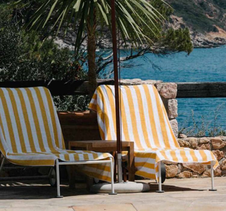 Striped towels on loungers overlooking the bay at Hotel Il Pellicano