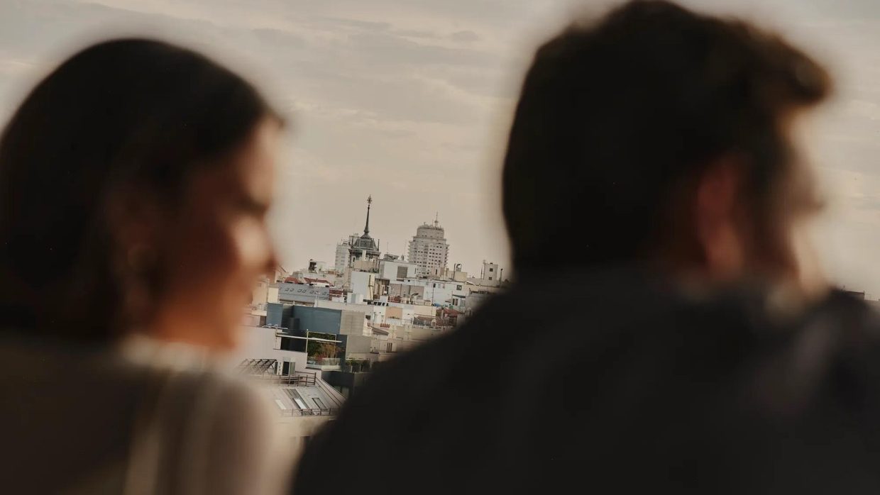 Two guests looking out over the rooftops of Madrid at dusk