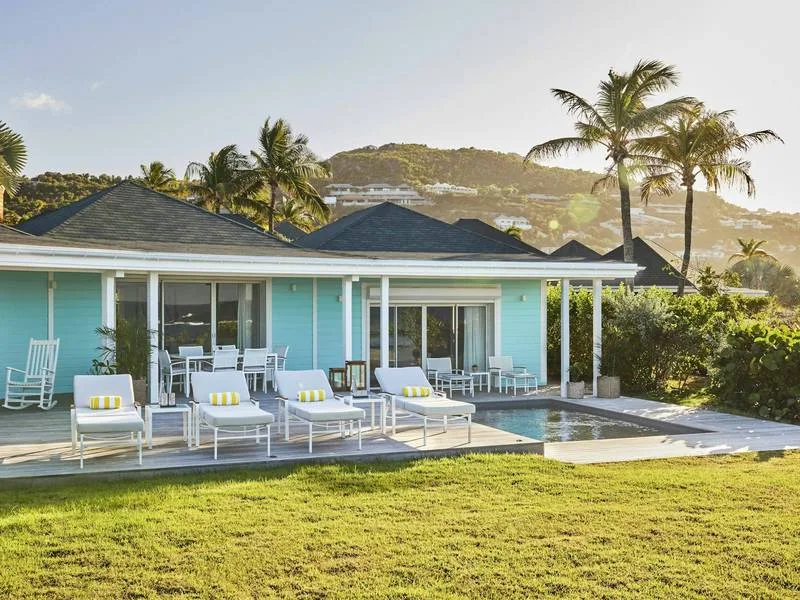 Pale turquoise Creole cottage with a lawn, loungers and plunge pool at Airelles Le Guanahani