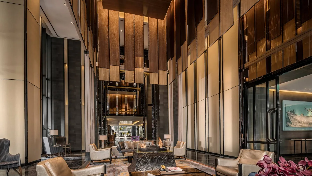 The double-height lobby of Four Seasons Hotel Seoul, panelled in warm timber and bronze